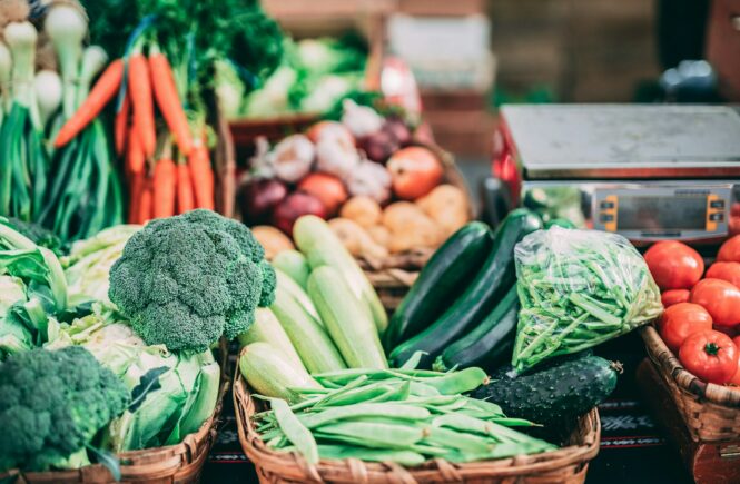 Étal de marché rempli de légumes frais et colorés dans des paniers en osier